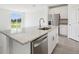 Stylish kitchen island with granite countertops, a stainless steel dishwasher, and a view of the backyard at 7740 Gilchrist Springs Dr, Parrish, FL 34219