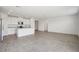 Spacious, open-concept living area with tile flooring and a modern kitchen with white cabinets and stainless appliances at 7740 Gilchrist Springs Dr, Parrish, FL 34219