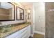 Modern bathroom with double sinks, granite counters, decorative mirrors and tiled shower at 12408 Golden Oak Cir, Hudson, FL 34669