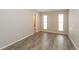 Neutral bedroom showcasing wood floors, light grey walls, and two windows at 12408 Golden Oak Cir, Hudson, FL 34669