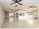 Bright living room featuring tiled floors, ceiling fans, and an open layout to the kitchen at 12408 Golden Oak Cir, Hudson, FL 34669