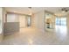 Open living space with tiled floors leading to kitchen area, closet, and backyard access at 12408 Golden Oak Cir, Hudson, FL 34669