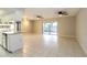 Living room flowing into the kitchen with tiled floors, ceiling fans, and sliding doors to the backyard at 12408 Golden Oak Cir, Hudson, FL 34669
