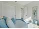 Bright bedroom featuring soft blue bedding, a modern painting, and light hardwood floors at 3339 Elkcam Blvd, Port Charlotte, FL 33952