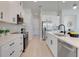 Modern kitchen with white cabinets, a stainless steel appliance suite, tile backsplash, and beautiful quartz countertops at 3339 Elkcam Blvd, Port Charlotte, FL 33952