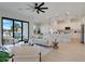 Open-concept living room featuring a ceiling fan and sliding glass doors adjacent to the kitchen at 3339 Elkcam Blvd, Port Charlotte, FL 33952