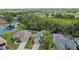 A high-angle view of the property and surrounding community, featuring lush trees and nearby pond at 5009 72Nd E Ct, Bradenton, FL 34203