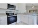 Stylish kitchen featuring stainless steel appliances, granite countertops, and white cabinetry at 5009 72Nd E Ct, Bradenton, FL 34203