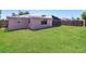 Spacious backyard showcasing a well-maintained lawn and rear home exterior at 7221 King Arthur Dr, Port Richey, FL 34668