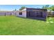 Home's backyard with a green lawn and a screened-in patio at 7221 King Arthur Dr, Port Richey, FL 34668