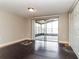 Cozy living room with dark wood floors and sliding glass doors to the patio at 7221 King Arthur Dr, Port Richey, FL 34668