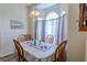 Formal dining room with wood table, upholstered chairs, and window with sheer curtains at 9475 Dunkirk Rd, Spring Hill, FL 34608