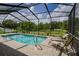 Inviting screened-in pool area featuring a sparkling pool and lounge chairs with views of the backyard at 9475 Dunkirk Rd, Spring Hill, FL 34608