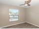 This bedroom provides natural light with a large window and a ceiling fan at 2597 Countryside Blvd # 204, Clearwater, FL 33761