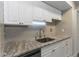 Beautiful kitchen featuring granite counters, white cabinets, and a stainless steel sink at 2597 Countryside Blvd # 204, Clearwater, FL 33761
