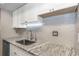 Updated kitchen with stainless steel sink, granite counters, and subway tile backsplash at 2597 Countryside Blvd # 204, Clearwater, FL 33761