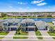 Aerial view of lakeside community featuring manicured lawns, and stylish two-story homes at 3061 Hollow Hickory Pl, Wesley Chapel, FL 33543