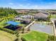 Aerial view showcasing a community playground, pool, and basketball court amidst lush greenery and residential homes at 3061 Hollow Hickory Pl, Wesley Chapel, FL 33543