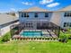 Aerial view of a home with a screened-in pool, patio, and landscaped backyard at 3061 Hollow Hickory Pl, Wesley Chapel, FL 33543