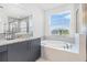 A bright bathroom featuring a soaking tub and granite countertops at 3061 Hollow Hickory Pl, Wesley Chapel, FL 33543
