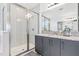 Modern bathroom featuring granite countertops, gray cabinets, and a glass-enclosed shower at 3061 Hollow Hickory Pl, Wesley Chapel, FL 33543