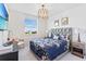 Stylish bedroom featuring a padded headboard, blue floral bedspread, and contemporary decor at 3061 Hollow Hickory Pl, Wesley Chapel, FL 33543