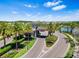 Community entrance featuring a grand entryway with palm trees and manicured landscaping at 3061 Hollow Hickory Pl, Wesley Chapel, FL 33543