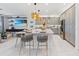 Open-concept kitchen with a center island, bar stools, and stainless steel appliances flows into the living area at 3061 Hollow Hickory Pl, Wesley Chapel, FL 33543