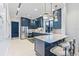 A modern kitchen features blue cabinets, a marble countertop island, and stainless steel appliances at 3061 Hollow Hickory Pl, Wesley Chapel, FL 33543