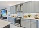 Modern kitchen features stainless steel appliances, gray cabinets, and ample counter space at 3061 Hollow Hickory Pl, Wesley Chapel, FL 33543