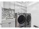 Well-equipped laundry room featuring modern washer, dryer, stylish countertops, and storage cabinets at 3061 Hollow Hickory Pl, Wesley Chapel, FL 33543