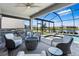 A screened-in patio features an outdoor kitchen, gas fire pit, and lake views at 3061 Hollow Hickory Pl, Wesley Chapel, FL 33543
