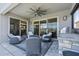 A covered outdoor seating area features an outdoor kitchen and lake views at 3061 Hollow Hickory Pl, Wesley Chapel, FL 33543