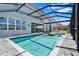 Relaxing screened-in pool area with patio seating and beautiful landscaping at 3061 Hollow Hickory Pl, Wesley Chapel, FL 33543