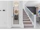 Staircase leading to wine cellar with glass door, carpeted steps, and a white banister at 3061 Hollow Hickory Pl, Wesley Chapel, FL 33543