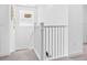 An all-white staircase featuring a simple railing design and a window illuminating the landing at 3061 Hollow Hickory Pl, Wesley Chapel, FL 33543