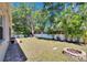 Large backyard with a brick fire pit, nice lawn and lush tropical landscaping at 12802 Cattail Shore Ln, Riverview, FL 33579