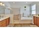Bathroom with a soaking tub, glass-enclosed shower, and double vanity sinks, all with modern fixtures at 12802 Cattail Shore Ln, Riverview, FL 33579