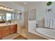 Bright bathroom with a glass shower, soaking tub, double vanity, and modern fixtures, offering a luxurious feel at 12802 Cattail Shore Ln, Riverview, FL 33579