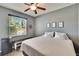 Bedroom with a window view, mini fridge, and modern decor, featuring gray walls and wood-look flooring at 12802 Cattail Shore Ln, Riverview, FL 33579