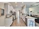 Well-lit kitchen with stainless appliances, white cabinets, and an adjacent living area at 12802 Cattail Shore Ln, Riverview, FL 33579