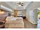 Spacious bedroom featuring a rustic wood headboard, tray ceiling, wood-look floors, and a backyard view at 12802 Cattail Shore Ln, Riverview, FL 33579