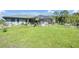Large grassy backyard featuring the screened in lanai and room for outdoor enjoyment at 268 Cory St, Port Charlotte, FL 33953