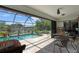 Enclosed lanai with a refreshing pool, dining set, and views of the backyard at 268 Cory St, Port Charlotte, FL 33953