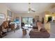 Comfortable living room with a vaulted ceiling, ceiling fan, and view of pool area through sliding glass doors at 268 Cory St, Port Charlotte, FL 33953