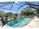 A screened in pool with brick border surrounded by lush landscaping at 268 Cory St, Port Charlotte, FL 33953