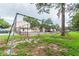 Community playground with swings and a slide, adjacent to a tennis court and residential buildings at 5504 Pokeweed Ct # 154, Tampa, FL 33617