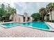 Inviting community pool with a brick surround, adjacent to a clubhouse and condo buildings at 5504 Pokeweed Ct # 154, Tampa, FL 33617