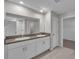 Bathroom featuring double sinks with granite countertops, white cabinets, and tile flooring at 10357 Scarlet Skimmer Dr, Riverview, FL 33578