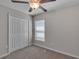 Carpeted bedroom with a ceiling fan, closet, and window with blinds at 10357 Scarlet Skimmer Dr, Riverview, FL 33578